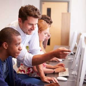 Image of teacher showing student how to do something on a computer